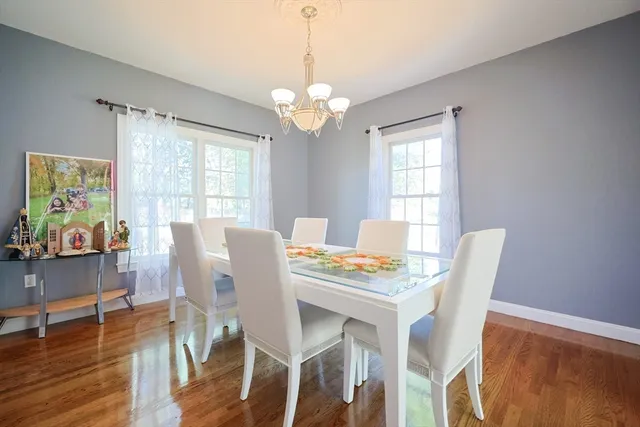 a view of a dining room with furniture a chandelier and wooden floor