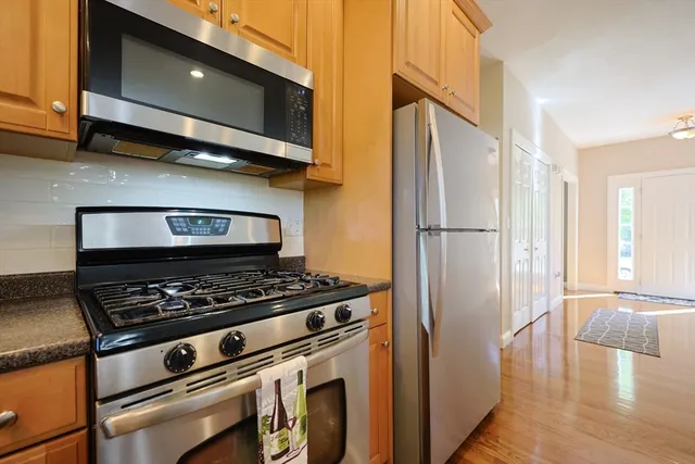 a kitchen with stainless steel appliances granite countertop a stove microwave and refrigerator