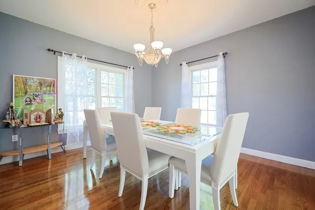 a view of a dining room with furniture a chandelier and wooden floor