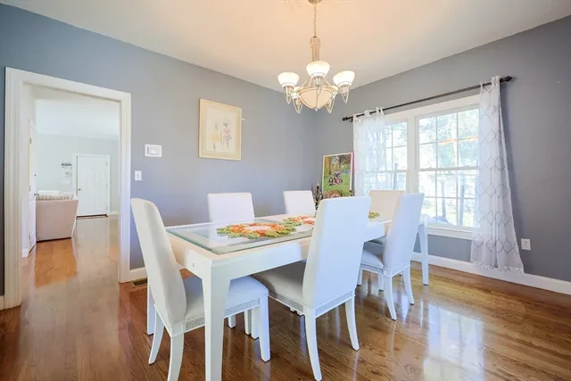 a view of a dining room with furniture a chandelier and wooden floor