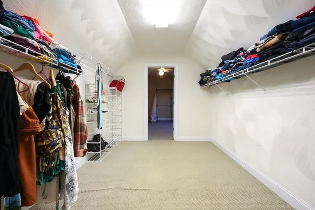 a view of walk in closet with clothes and shoes