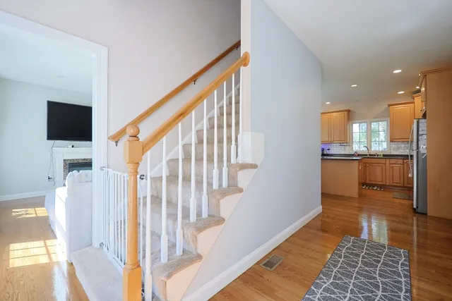 a view of a hallway with wooden floor and a living room