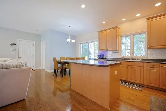 a kitchen with granite countertop a stove a sink a dining table and chairs