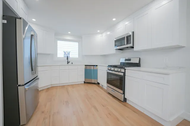 a kitchen with stainless steel appliances a refrigerator sink and microwave