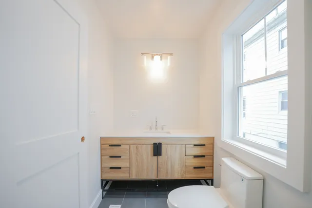 a bathroom with a window vanity and a mirror