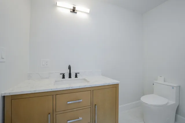 a bathroom with a sink toilet and a mirror