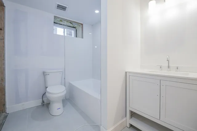 a bathroom with a sink a toilet and shower