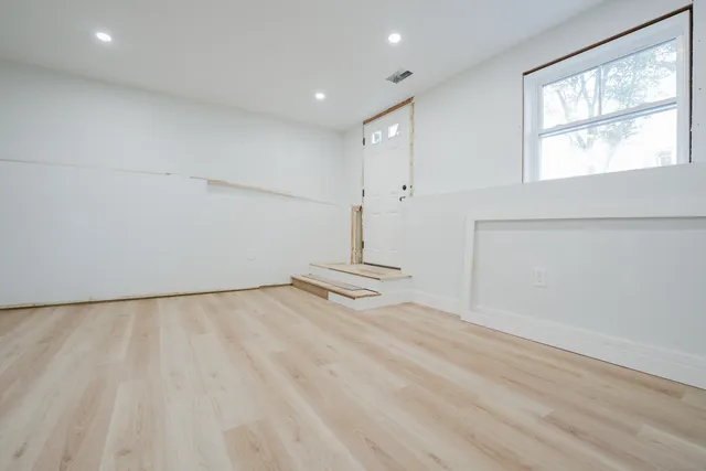 wooden floor in an empty room with a window