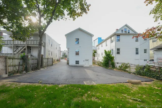 a view of a house with a yard and large tree