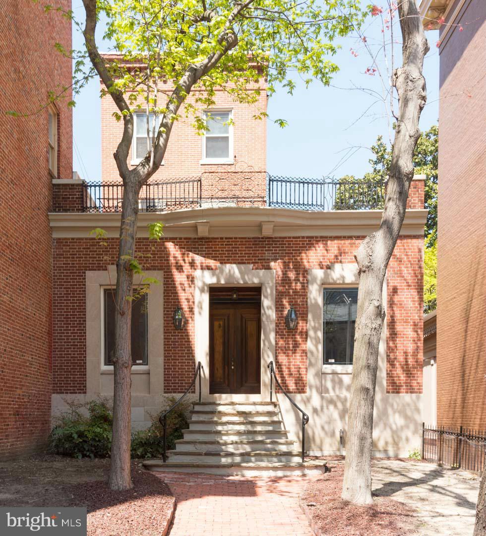 a front view of a house with a tree
