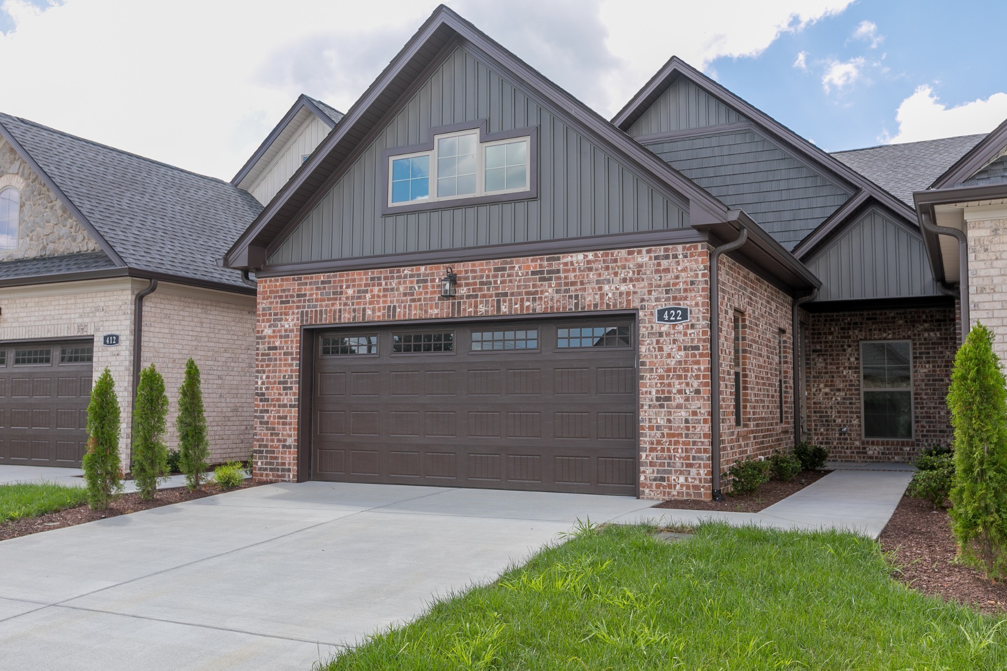 a front view of a house with a garden and garage