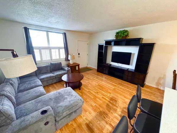 a living room with furniture and a wooden floor