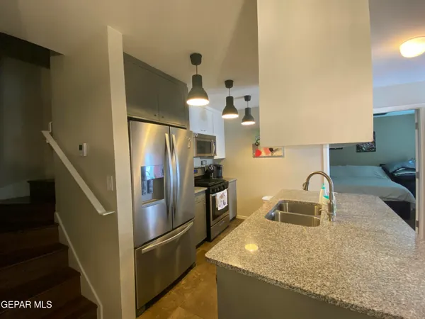 a kitchen with granite countertop a refrigerator and a sink