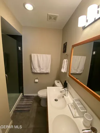 a bathroom with a double vanity sink mirror and toilet