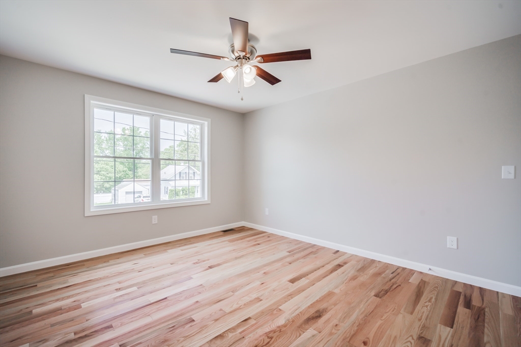 27 Jennings Street Springfield, MA 01119 - Photo 19 of 32 an empty room with wooden floor fan and windows