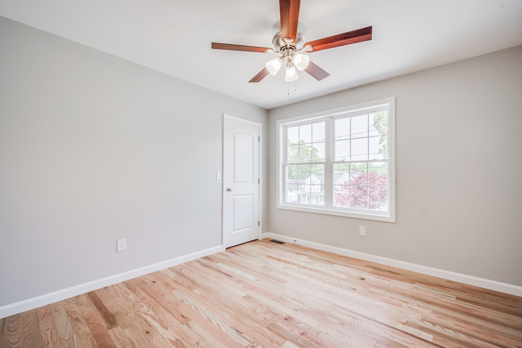 27 Jennings Street Springfield, MA 01119 - Photo 22 of 32 an empty room with wooden floor chandelier fan and windows