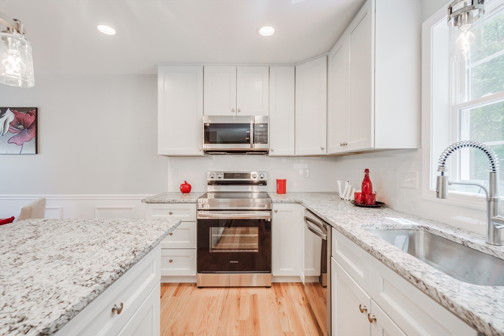27 Jennings Street Springfield, MA 01119 - Photo 10 of 32 a kitchen with stainless steel appliances granite countertop a sink stove and refrigerator