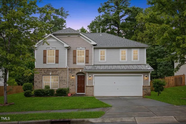 a front view of a house with a yard and garage