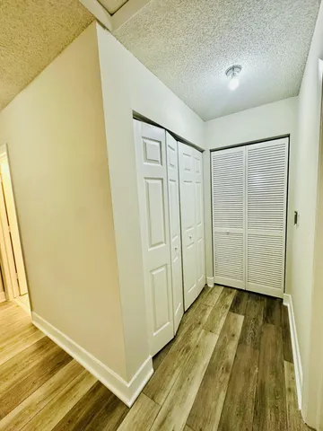a view of a room with wooden floor and a window