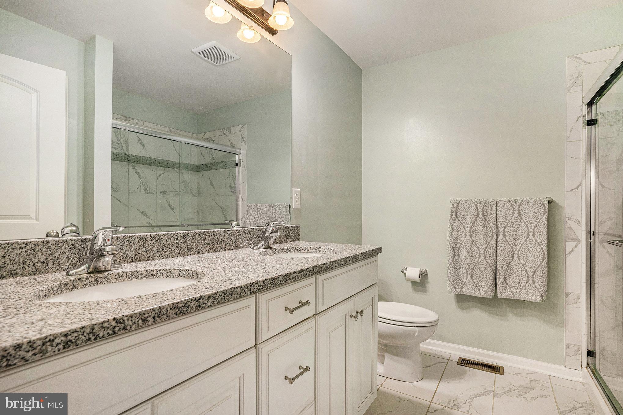 3611 Jacob Stout Road, Unit 8 Doylestown, PA 18902 - Photo 21 of 39 a bathroom with a granite countertop sink a toilet and a mirror
