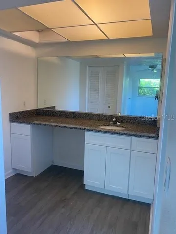 a kitchen with granite countertop cabinets and wooden floor