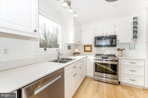 a kitchen with stainless steel appliances a stove a sink and a microwave