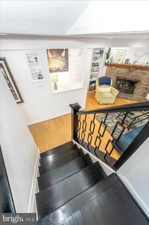 a living room with stainless steel appliances furniture and a wooden floor