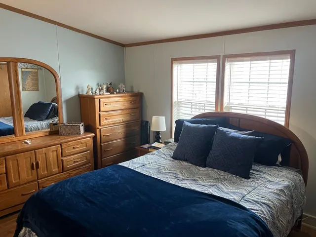 a bedroom with a bed and dresser with mirror