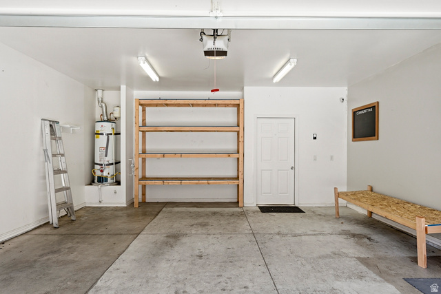 1177 Northfield Road, Unit 26 Cedar City, UT 84721 - Photo 32 of 45 Spacious garage featuring concrete flooring, built-in wooden shelving, overhead lighting, and a paneled entry door