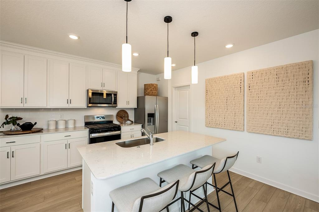 6263 Broad Fld Avenue Apollo Beach, FL 33572 - Photo 2 of 24 a kitchen with stainless steel appliances a stove a sink a refrigerator a center island and a wooden floor