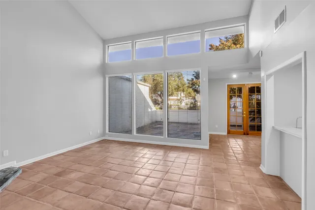 a view of a hallway with wooden floor and a refrigerator
