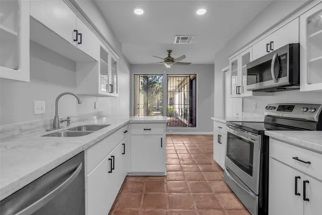 a kitchen with stainless steel appliances granite countertop a sink and a stove