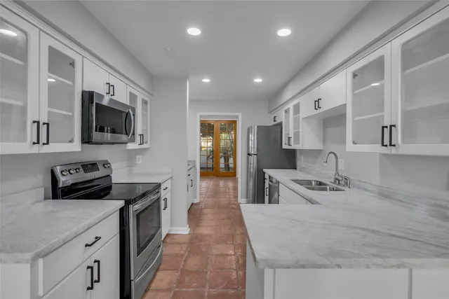 a kitchen with stainless steel appliances granite countertop a sink and stove top oven with wooden floor