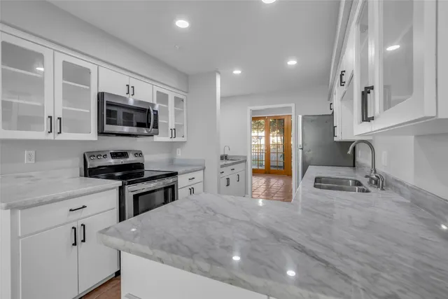a kitchen with stainless steel appliances a stove sink microwave and cabinets