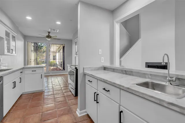 a spacious bathroom with a granite countertop sink a mirror and bathtub