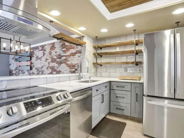a kitchen with stainless steel appliances white cabinets and a refrigerator