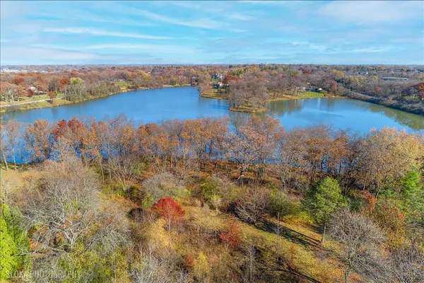an aerial view of residential houses with outdoor space and lake view