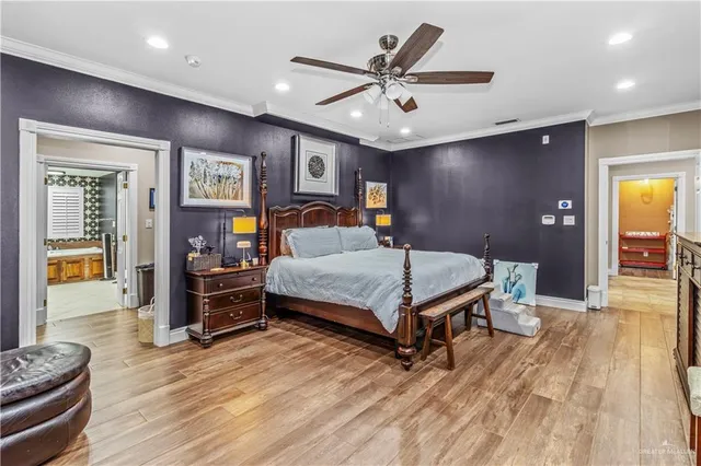 a bedroom with a bed a dresser and potted plant with wooden floor