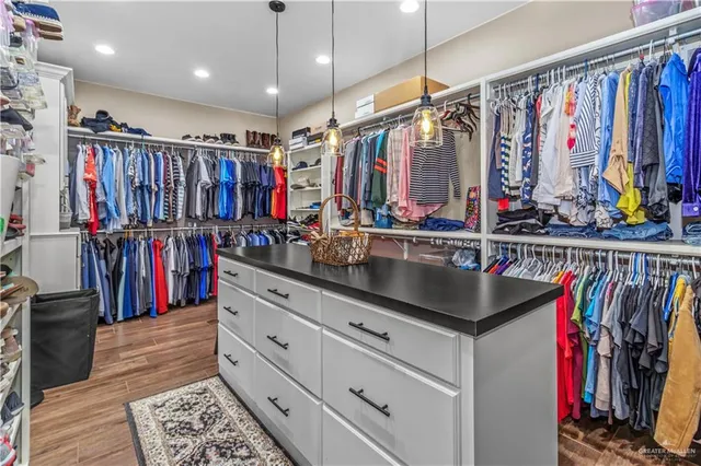 a view of walk in closet with clothes and shoes