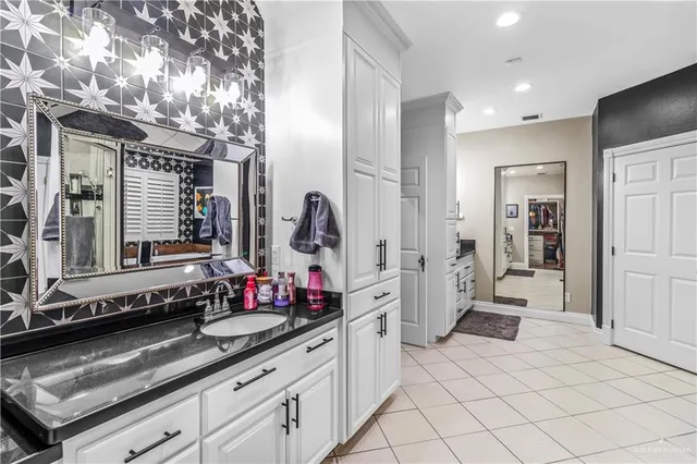 view of a kitchen with granite countertop a sink and cabinets