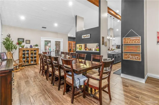 a view of a dining room and livingroom with furniture wooden floor a rug and a painting