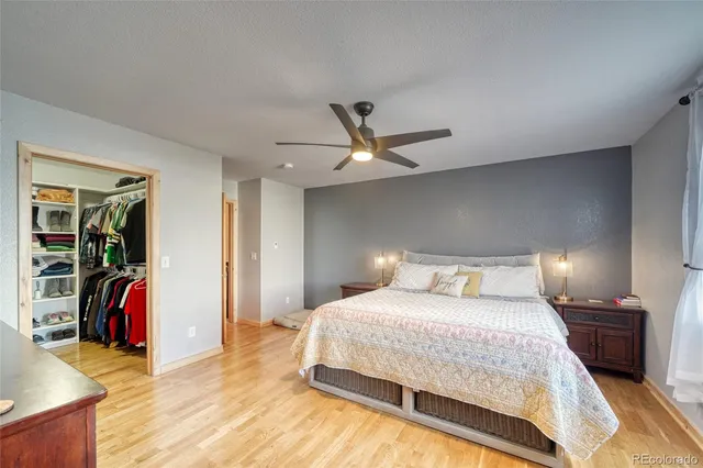 a bedroom with a bed a large window and a chandelier