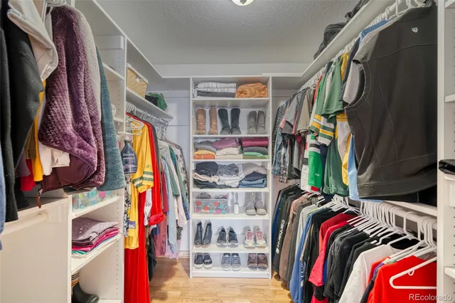 a view of walk in closet with clothes and shoes