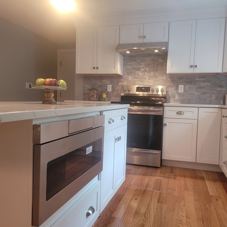 54 Summer Street North Andover, MA 01845 - Photo 8 of 25 a kitchen with a stove and white cabinets