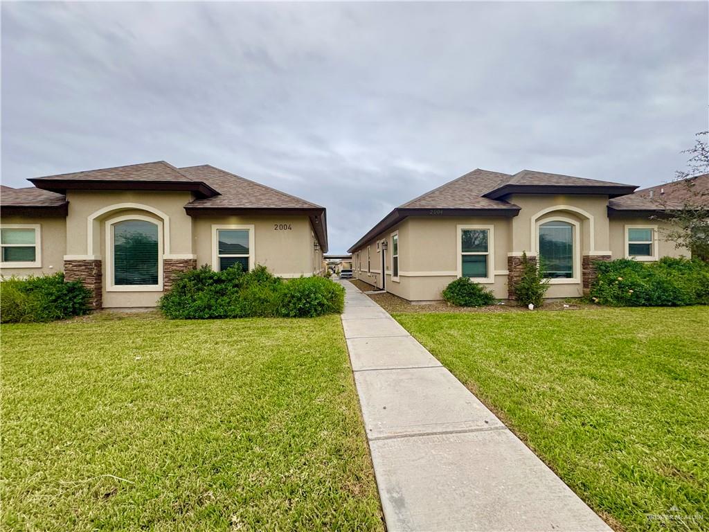 2004 Taft Street, Unit 1 Weslaco, TX 78599 - Photo 1 of 16 a front view of a house with a yard