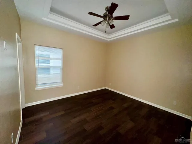 a view of a big room with wooden floor and windows