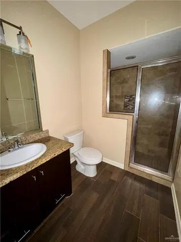 a bathroom with a granite countertop sink toilet a mirror and shower
