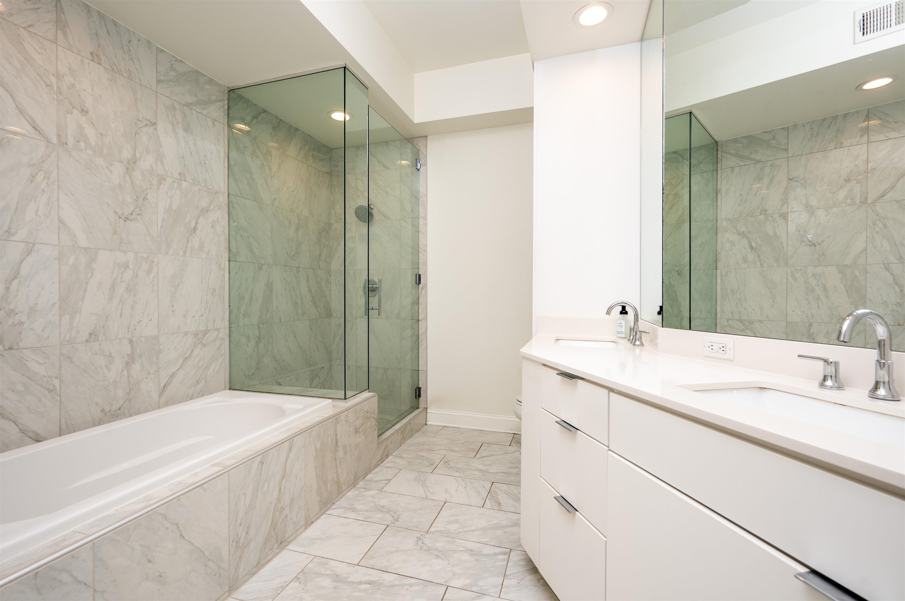 717 Riverside Drive, Unit 904 Memphis, TN 38103 - Photo 15 of 33 a bathroom with a granite countertop sink mirror bathtub and shower