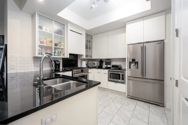 a kitchen with cabinets stainless steel appliances and a counter space