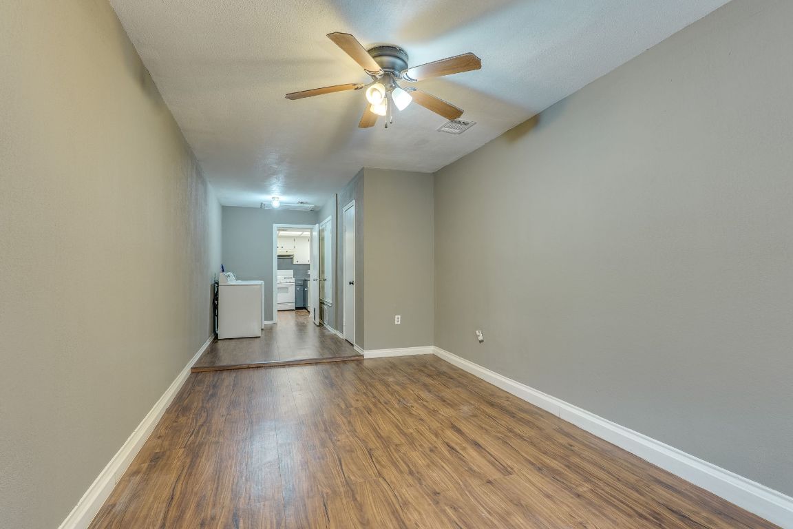 16041 Stoneham Circle Pflugerville, TX 78660 - Photo 21 of 34 a view of a room with wooden floor and a ceiling fan